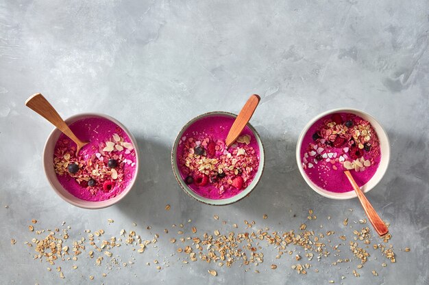 Pratos de smoothies com framboesas, granola e sementes de gergelim