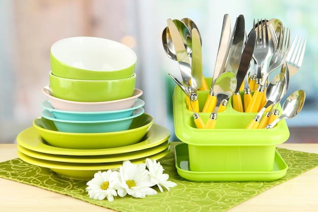 Pratos garfos facas colheres e outros utensílios de cozinha em guardanapo colorido em fundo brilhante