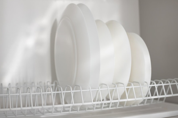 Pratos limpos brancos na prateleira da cozinha