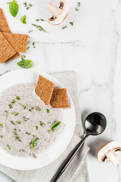 Pratos quentes de outono. Sopas veganas. Sopa creme de cogumelos com champignon frito e ervas, tomilho. Em uma mesa de mármore branco. vista superior copyspace