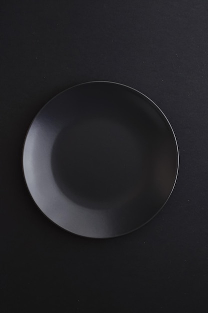 Pratos vazios em louça premium de fundo preto para dieta e design minimalista de jantar de férias