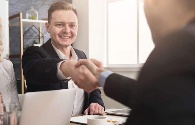 Prazer em conhecê-lo. aperto de mão de executivos na primeira reunião, parceiros alegres se cumprimentando, copie o espaço