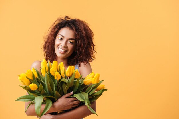 Foto prazer mulher africana, abraçando o buquê de flores