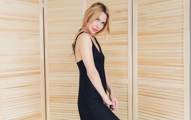 Preciosa joven rubia con un pequeño vestido negro