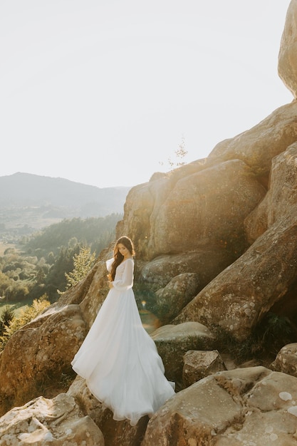 Preciosa novia rubia contra el telón de fondo de las montañas en Italia.