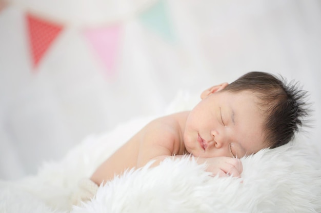 Foto precioso bebé asiático recién nacido durmiendo en tela peluda