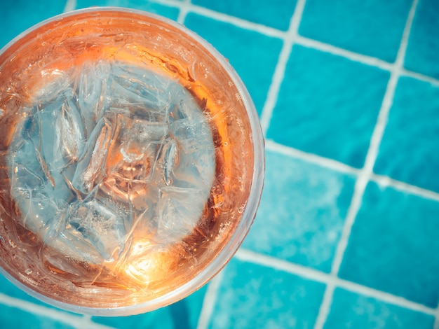 Precioso vaso con cóctel rosa y cubitos de hielo.