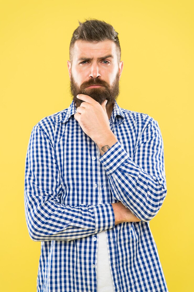 Foto precisando de um barbeiro para modelar a barba homem barbudo pensando em visitar o barbeiro hipster pensativo tocando o queixo não barbeado antes de ir à barbearia aparar a barba como um mestre barbeiro