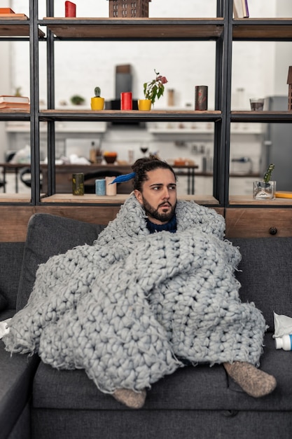 Foto preciso descansar. moreno legal sentado no sofá enquanto descansa em casa