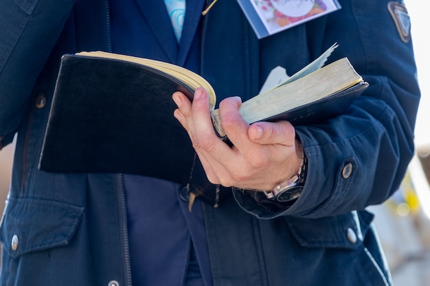 Un predicador sostiene una Biblia y lee un pasaje de ella.