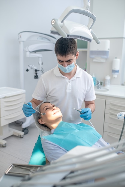 Preenchimento dentário. Dentista trabalhando na restauração de dentes de pacientes e fazendo obturação dentária