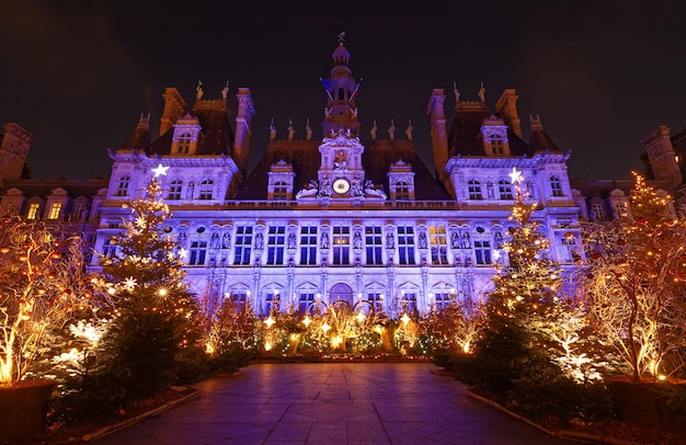 Prefeitura parisiense decorada com árvores de Natal para férias de inverno à noite Viagens de inverno