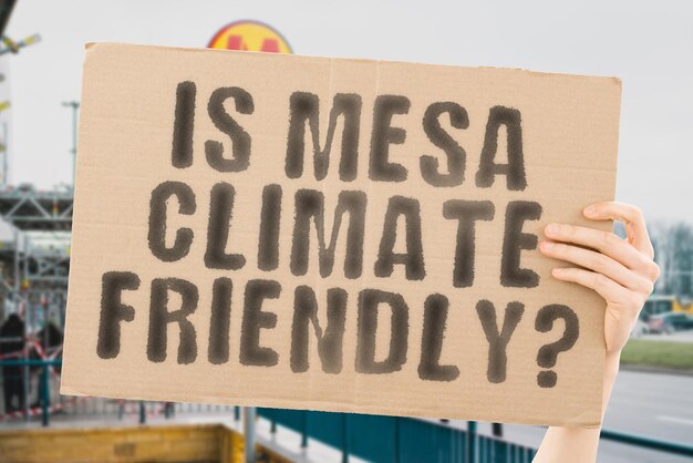 La pregunta ¿Es Mesa amigable con el clima? está en una pancarta en las manos de los hombres con un fondo borroso Equipo de apoyo Activista Atardecer urbano Carbono Ecología Energía Nuevo Calentamiento limpio Residuos