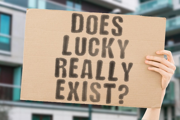 La pregunta: ¿Existe realmente la suerte en una pancarta en la mano de un hombre con un fondo borroso?