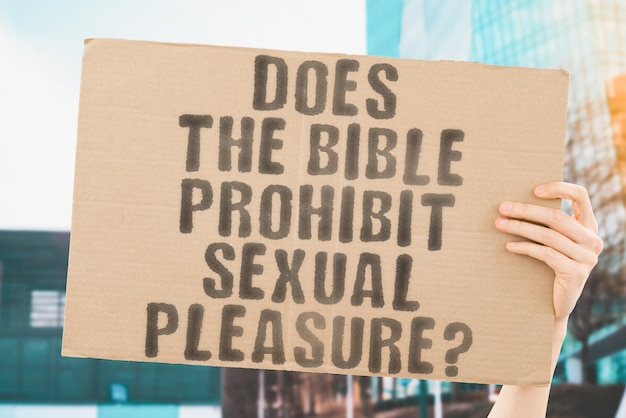 La pregunta ¿Prohíbe la Biblia el placer sexual? Está en una pancarta en las manos de los hombres con un fondo borroso Éxtasis sexual Novia Intimidad Figura malvada erótica Pecado Cristo bíblico Cama