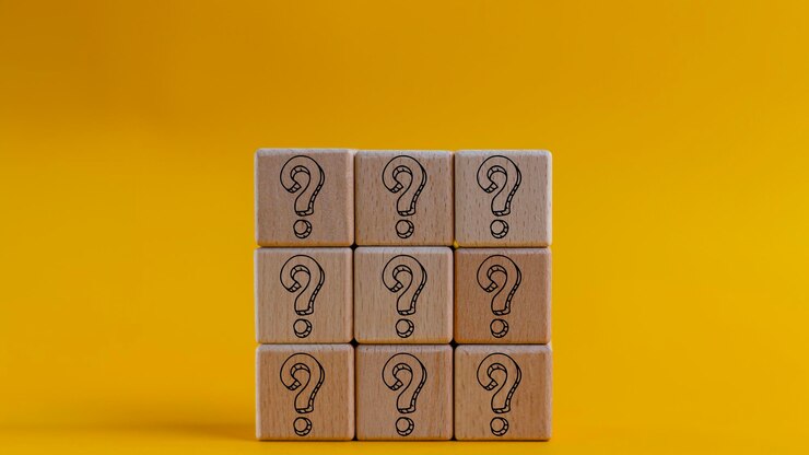 Foto preguntas marque las palabras con un bloque de cubo de madera en un fondo amarillo preguntas frecuentes preguntas formuladas respuesta q y a información comunicación y conceptos de lluvia de ideas