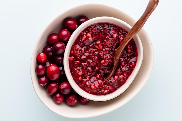 Preiselbeeren in weißer Schüssel auf pastellfarbenem Hintergrund