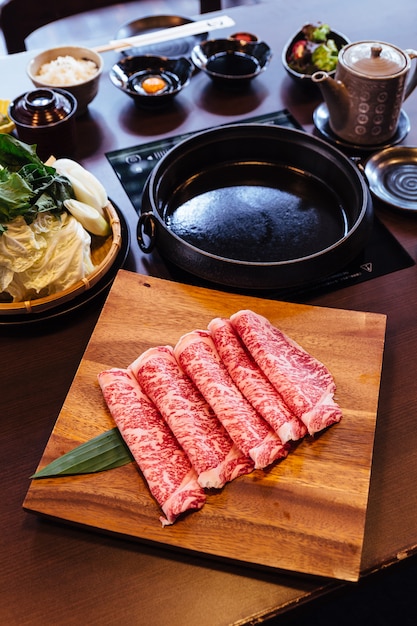 Premium Rare Slices Wagyu A5 de carne de vacuno con textura de mármol en un plato cuadrado de madera.