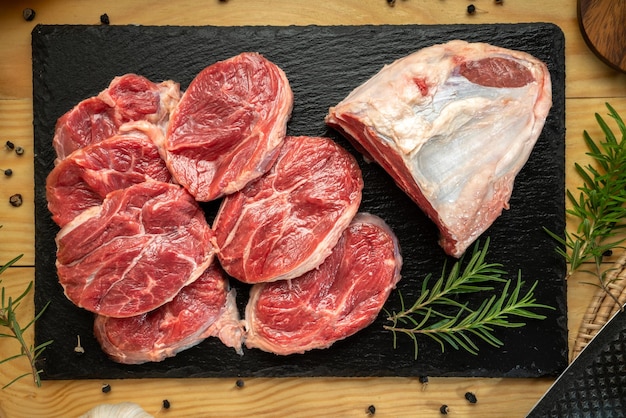 Premium Shank Beef in schwarzer Steinplatte auf Holzhintergrund Frisches Silberschenkelfleisch in schwarzer Platte