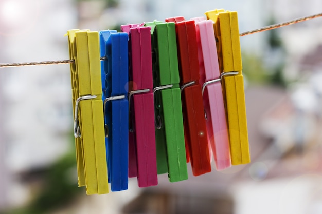 Prendedores de roupa coloridos pendurado em uma corda em um fundo da cidade