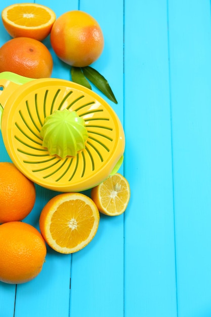 Foto prensa de cítricos y frutas sobre fondo de madera