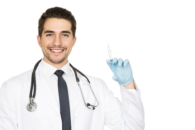 Sin preocupaciones. Retrato de un médico varón guapo alegre sosteniendo una inyección sonriendo ampliamente aislado en blanco