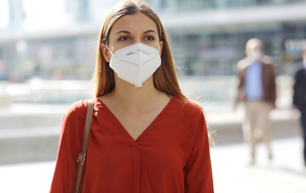 Preocupada joven empresaria con mascarilla caminando