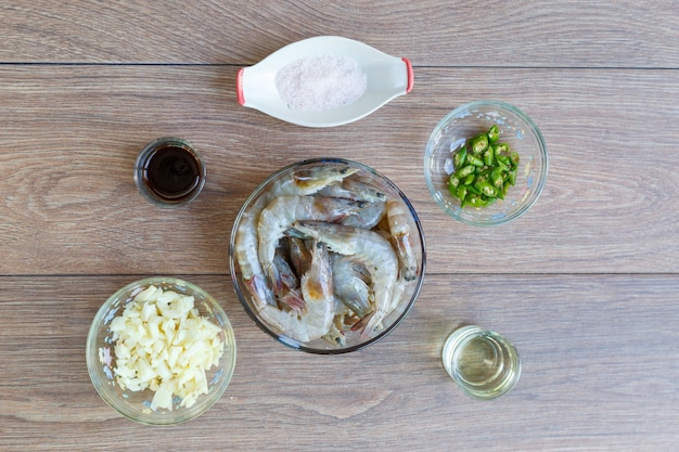 Preparação antes de cozinhar mexa o camarão frito com pimenta, alho e sal na mesa de madeira. vista superior ou configuração plana.