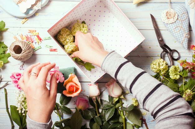 Preparação da caixa de flores com macaroons, vista superior do local de trabalho da florista