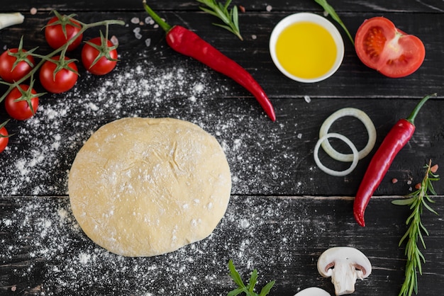 Preparação da massa e legumes para produção de pizza