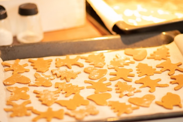 Preparação de biscoitos de gengibre de sobremesa de Natal figuras de pão de gengibre para assar em uma assadeira