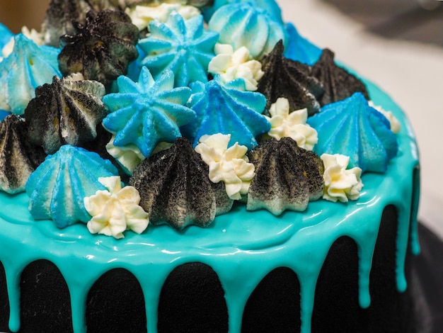 Preparação de bolo de xícara pintado de preto fosco com gotejamento azul turquesa
