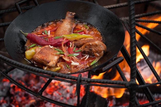 Preparação de carne de frango na fogueira