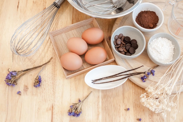 Preparação de cozimento de vista superior na mesa de madeiraIngredientes de cozimento Tigela de ovos e rolo de farinha e cascas de ovos na placa de madeiraConceito de cozimento