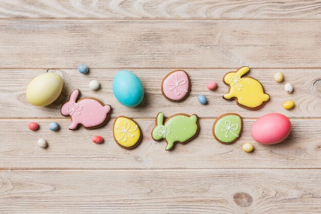 Preparação de férias Ovos de páscoa de várias cores com biscoitos em fundo colorido Conceito de férias de ovos de páscoa de cor pastel com espaço de cópia