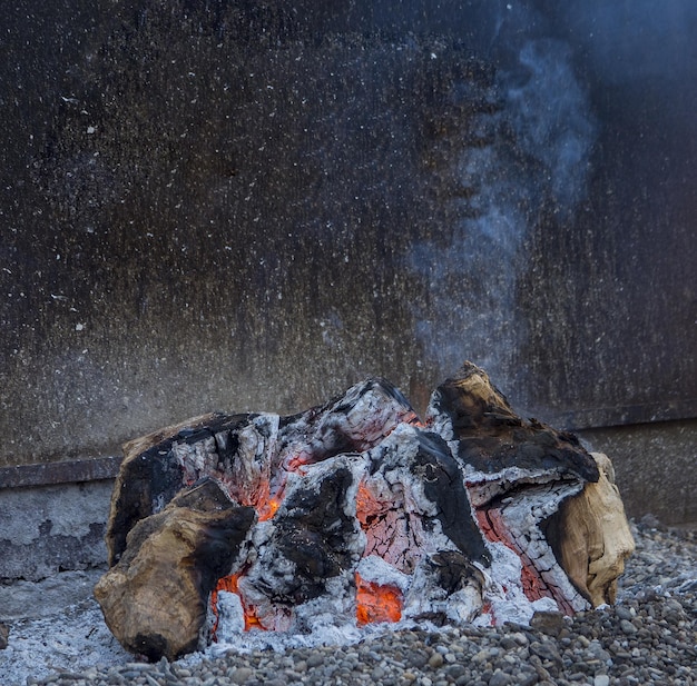 Preparação de fogo para grelhar, trabalhar em chamas de lenha de carvão aceso fazer fogo em uma fogueira.