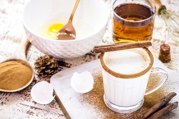 Preparação de gemada natalina, receita de bebida natalina, com ovos, açúcar, canela, rum e creme