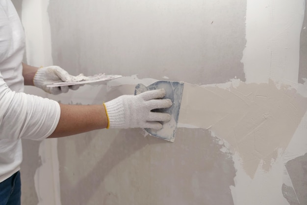 Preparação de gesso e pintura de parede Masculino asiático aplicando enchimento de drywall patchx9