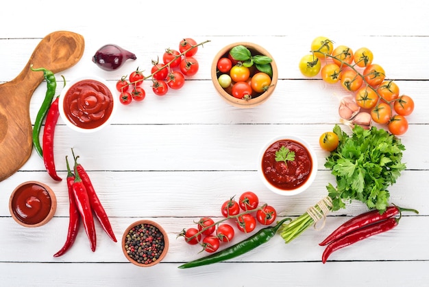 Preparação de molhos de tomate e temperos tomate cereja especiarias pimentas vista superior em um fundo branco de madeira espaço para cópia grátis