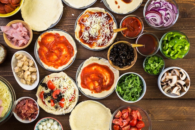 Preparação de pizzas individuais em pizzaria.