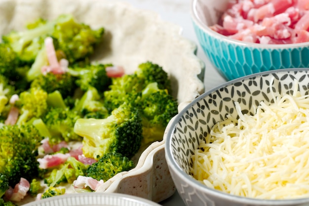 Preparação de quiche com brócolis, queijo e bacon