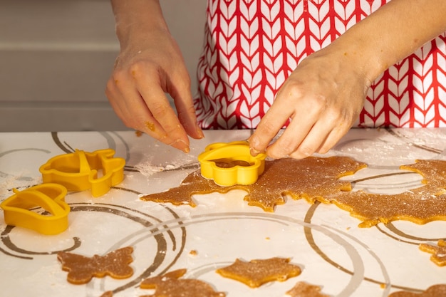 Preparação de sobremesas Mãos femininas recortam formas para biscoitos