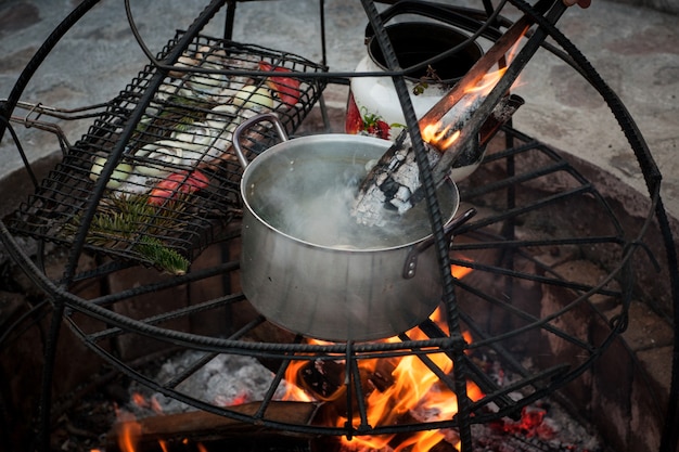 Preparação de sopa e peixe na fogueira