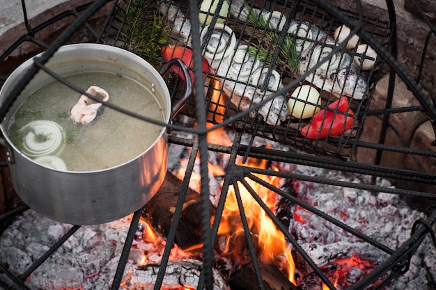 Preparação de sopa e peixe na fogueira