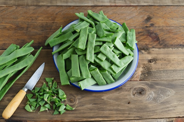Preparação de vegetais para cozinhar. Feijão verde cortado em um prato. Copie o espaço.