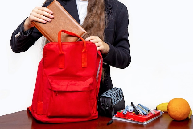 Preparação matinal para a escola Uma estudante recolhe uma bolsa para a escola Há material escolar em