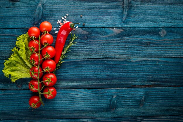 Preparação para cozinhar tomate cereja legumes frescos e especiarias em um fundo de madeira vista superior