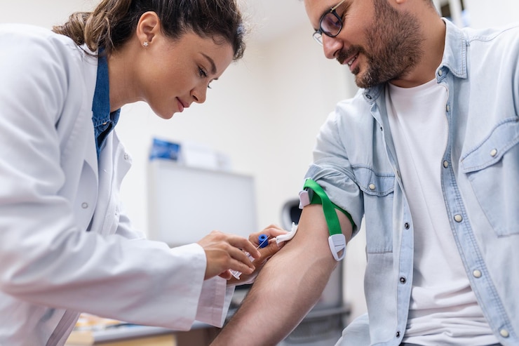 Preparação para exame de sangue por uma médica uniforme médico na mesa em uma sala branca e brilhante A enfermeira perfora a veia do braço do paciente com um tubo vazio de agulha