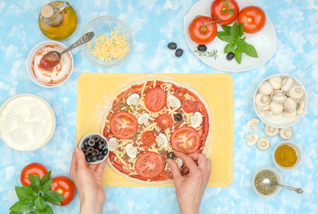 Preparação passo a passo de pizza vegetariana caseira, passo 8 - coloque azeitonas no queijo