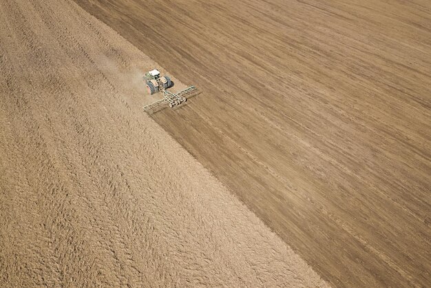 Preparación del campo del tractor para plantar, vista aérea. Cultivo de campo.